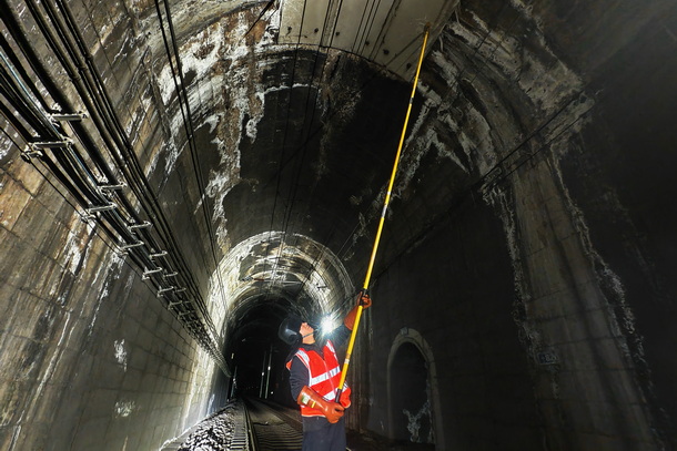 图为供电维修工正在进行隧道打冰作业